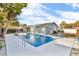 A backyard view of a refreshing in-ground swimming pool surrounded by a concrete patio in a private backyard at 15950 Adobe Dr, Hudson, FL 34667
