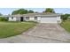 Single-story home with a white exterior, attached garage, and large front lawn at 2118 Huntington Ave, Sarasota, FL 34232