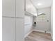 Bright laundry room with white cabinets, folding counter, and wood-look flooring at 2118 Huntington Ave, Sarasota, FL 34232