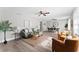 Open concept living and dining area with wood-look flooring, ceiling fans, and stylish furnishings at 2118 Huntington Ave, Sarasota, FL 34232