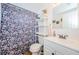 Well-lit bathroom with a floral shower curtain and decorative shelving at 3444 Clydesdale Dr, Holiday, FL 34691