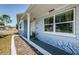 View of the front entrance featuring a quaint porch, lovely landscaping, and stone accents at 3444 Clydesdale Dr, Holiday, FL 34691