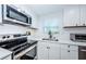 Modern kitchen boasts stainless steel appliances, white shaker cabinets, and sleek countertops at 3444 Clydesdale Dr, Holiday, FL 34691