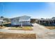 Light blue manufactured home with carport and landscaped yard at 3844 Kim Dr, Wesley Chapel, FL 33543