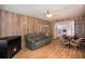 Cozy living area with fireplace, wood paneling, and open view to kitchen at 3844 Kim Dr, Wesley Chapel, FL 33543