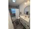 Modern bathroom with gray tile, white vanity, and arched mirror at 4629 26Th S Ave, St Petersburg, FL 33711