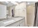 Bright bathroom featuring a granite vanity top, white cabinetry, and a walk-in shower with tiled walls at 4846 Leyte Ct, New Port Richey, FL 34655