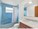 Clean bathroom with blue tile, a shower/tub combo, and vanity at 6288 Airmont Dr, Spring Hill, FL 34606