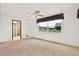 Simple carpeted bedroom with window and access to bathroom at 6288 Airmont Dr, Spring Hill, FL 34606