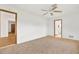 Spacious carpeted bedroom with ceiling fan and access to other rooms at 6288 Airmont Dr, Spring Hill, FL 34606