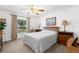 A cozy bedroom with ceiling fan, carpeted flooring, and wooden furniture at 6409 Wedgewood Dr, Spring Hill, FL 34606