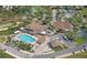 Aerial view of a golf course clubhouse with pool, tennis courts, and parking lot at 6409 Wedgewood Dr, Spring Hill, FL 34606