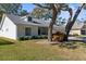Single-story home with white exterior, large trees, and green lawn at 6409 Wedgewood Dr, Spring Hill, FL 34606