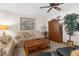Living area with floral sofa, ceiling fan, entertainment center, and potted plant at 6409 Wedgewood Dr, Spring Hill, FL 34606