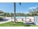Community pool surrounded by a lawn and shaded seating area at 6409 Wedgewood Dr, Spring Hill, FL 34606