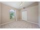 Bright bedroom with ceiling fan, tiled flooring and arched window with closet at 714 Charlotte Ave, Tarpon Springs, FL 34689