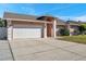 Front exterior view of a single-story home with attached garage and driveway at 714 Charlotte Ave, Tarpon Springs, FL 34689