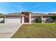 Single-story home with attached garage, driveway, and front yard at 714 Charlotte Ave, Tarpon Springs, FL 34689