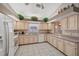 Kitchen with light wood cabinets, white appliances, and tile flooring at 714 Charlotte Ave, Tarpon Springs, FL 34689