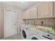 Laundry room with washer, dryer, and overhead cabinets at 714 Charlotte Ave, Tarpon Springs, FL 34689