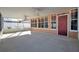 Screened porch with concrete flooring, ceiling fans, and a red door at 714 Charlotte Ave, Tarpon Springs, FL 34689