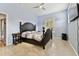 Blue bedroom with a dark wood bed, ceiling fan, and a view of the trees outside the window at 7717 Foxbear Ct, New Port Richey, FL 34655