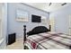 Light and airy bedroom with a dark wood bedframe, ceiling fan, and wall-mounted TV at 7717 Foxbear Ct, New Port Richey, FL 34655