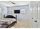 Blue bedroom with a dark wood bed, ceiling fan, and wall-mounted TV at 7717 Foxbear Ct, New Port Richey, FL 34655