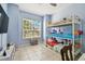 ' bedroom featuring bunk beds, blue walls, and large window at 7717 Foxbear Ct, New Port Richey, FL 34655