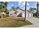 Single-story home with a two-car garage, palm trees, and landscaped front yard at 7717 Foxbear Ct, New Port Richey, FL 34655