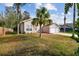 Attractive single-story home with palm trees, a fenced yard, and a two-car garage at 7717 Foxbear Ct, New Port Richey, FL 34655