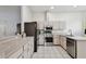 Kitchen boasts stainless steel appliances, white cabinets, and tile flooring at 7717 Foxbear Ct, New Port Richey, FL 34655