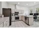 Bright kitchen features stainless steel appliances, white cabinetry, and tile floor at 7717 Foxbear Ct, New Port Richey, FL 34655