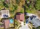 Top-down aerial view highlighting the home's roof, pool, and surrounding yards at 7717 Foxbear Ct, New Port Richey, FL 34655