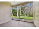 Spacious enclosed patio or sunroom with tile flooring and screened windows showcasing lush backyard views at 7717 Foxbear Ct, New Port Richey, FL 34655