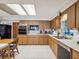 Kitchen featuring wood cabinetry, black appliances, and white countertops at 8440 Airway Blvd, New Port Richey, FL 34654