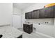 Laundry room with dark cabinets and granite counters at 10451 Gypsy Ave, Weeki Wachee, FL 34613