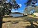 House backyard with a large green lawn and trees at 11556 Linden Dr, Spring Hill, FL 34608