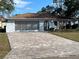 Ranch-style home with paved driveway and mature landscaping at 11556 Linden Dr, Spring Hill, FL 34608