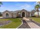 Exterior of a tan two-story house with a walkway and landscaping at 14101 Andrew Scott Rd, Spring Hill, FL 34609