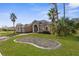 Tan house with palm trees, grassy yard, and a brick driveway at 14101 Andrew Scott Rd, Spring Hill, FL 34609