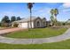 Tan house with palm trees, grassy yard, and a brick driveway at 14101 Andrew Scott Rd, Spring Hill, FL 34609