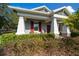 Relaxing front porch with red rocking chairs and lush landscaping at 19771 Tattnall Way, Brooksville, FL 34601