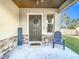 Inviting front porch with stonework, a dark brown door, and a blue chair at 2509 Magellan Ave, Spring Hill, FL 34608