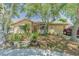 Tan house with brown roof, landscaping, and driveway at 3049 Moog Rd, Holiday, FL 34691