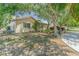 Tan house with brown roof, landscaping, and driveway, view from the side at 3049 Moog Rd, Holiday, FL 34691