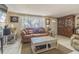 Living room with brown couch, coffee table, and wooden cabinet at 3049 Moog Rd, Holiday, FL 34691