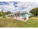 Quaint light teal home with a screened porch and small lawn at 4209 Prince Pl # A, New Port Richey, FL 34652