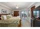 King-size bed in a well-lit bedroom with balcony access and a large TV at 4516 Seagull Dr # 413, New Port Richey, FL 34652