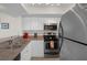 Galley kitchen with stainless steel appliances and granite counters at 4550 Bay Blvd # 1237, Port Richey, FL 34668